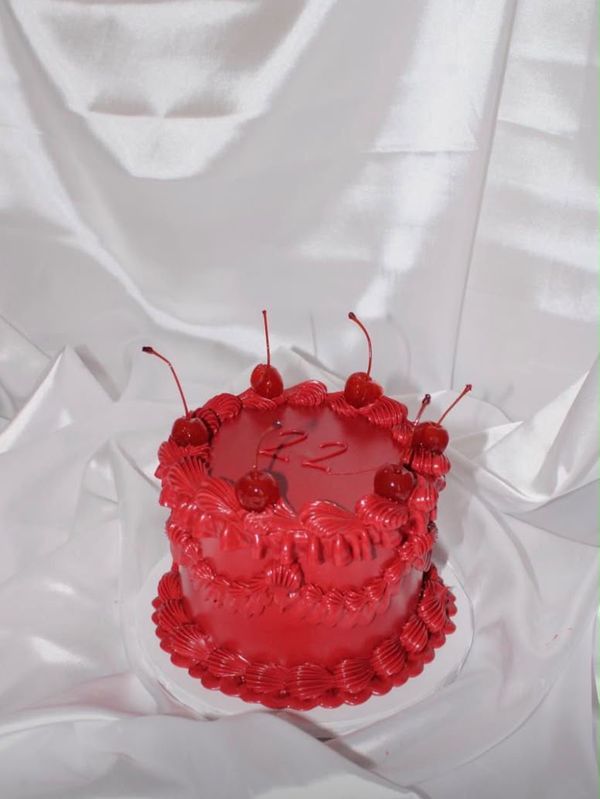 A small red cake with cherries