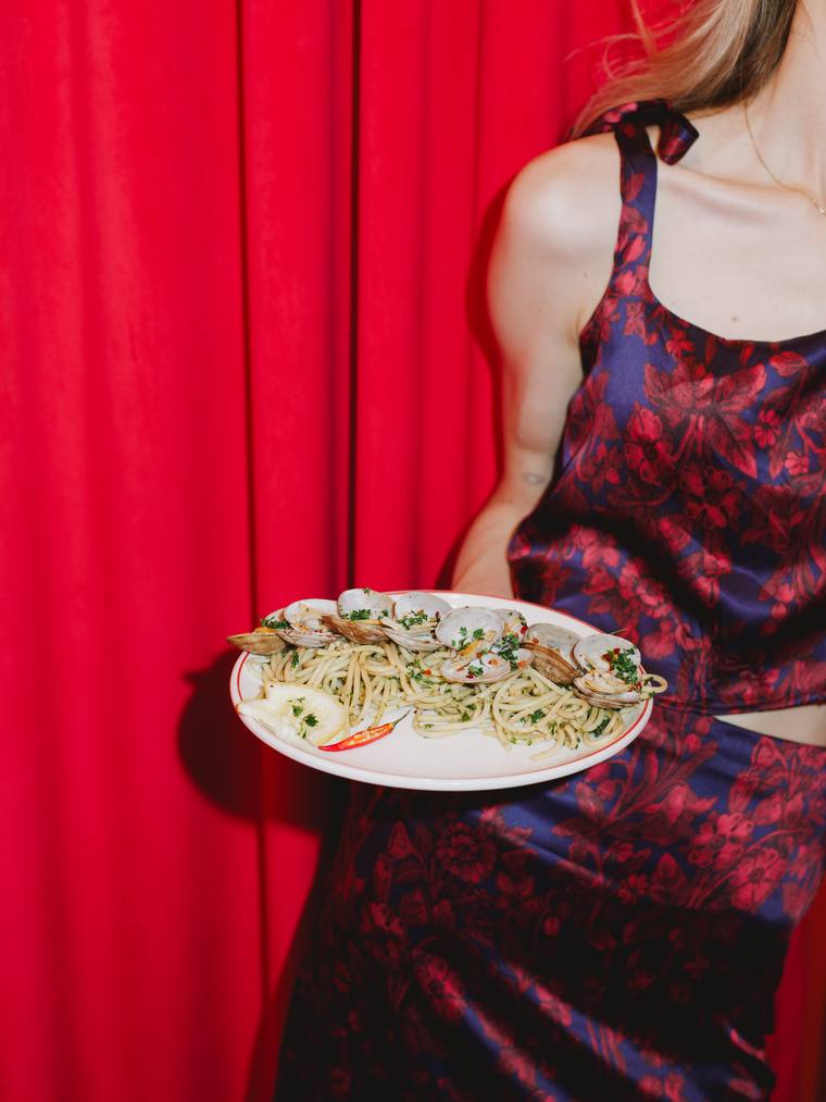 A plate of pasta carried past the red curtain