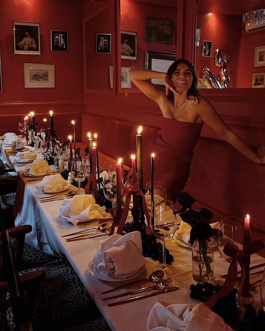 The Libertino signature table: a long table of candles, red ribbons, black grapes and folded linen